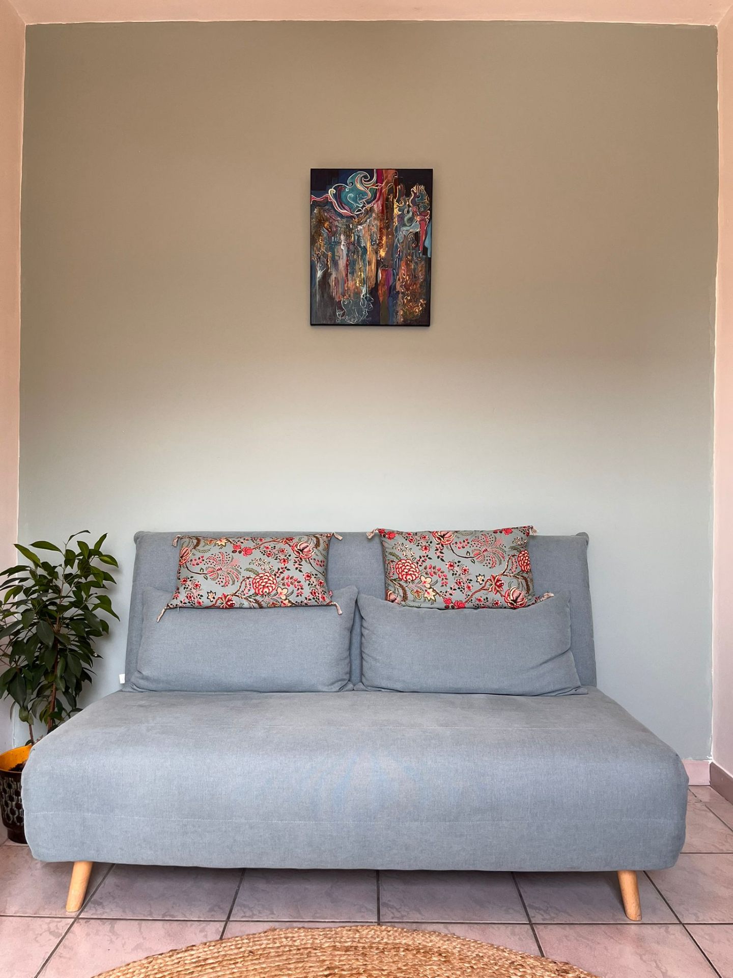 Espace d'accueil avec canapé et tableau d'art au mur